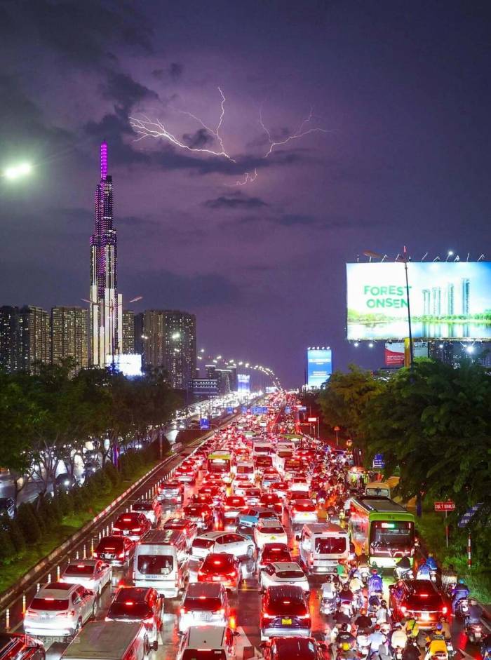 Giông sét trên bầu trời trung tâm TP HCM nhìn từ cầu bộ hành tại ga metro Thảo Điền, tối 1/10. Ảnh: Quỳnh Trần