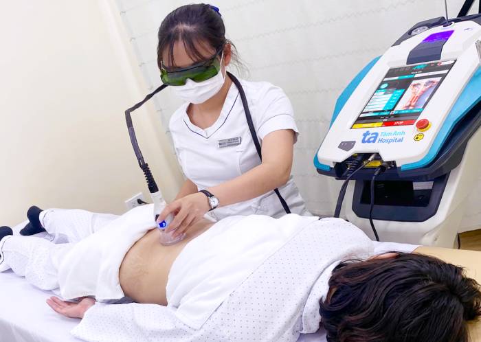 Nhân viên y tế trị liệu laser giúp người bệnh giảm đau đa mô thức. Ảnh: Bệnh viện Đa khoa Tâm Anh