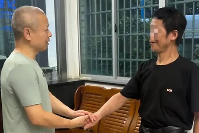 Ông Zu, bên phải, cảm ơn các nhân viên xã hội hỗ trợ mình. Ảnh: QQ.com