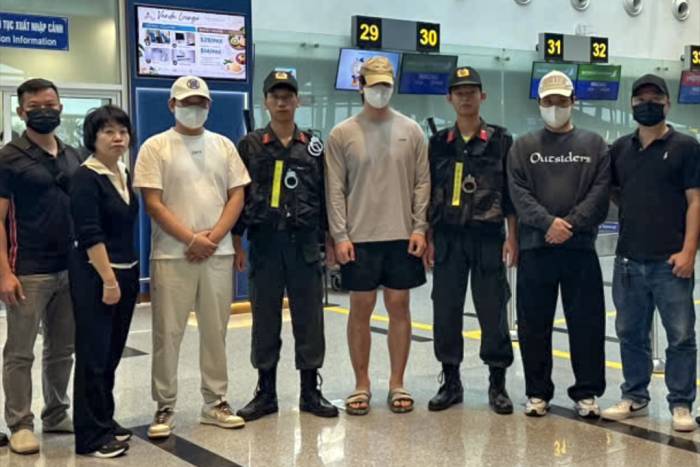 Ba người Hàn Quốc (đội mũ lưỡi trai) khi bàn giao tại sân bay quốc tế Đà Nẵng. Ảnh: Thành Huynh