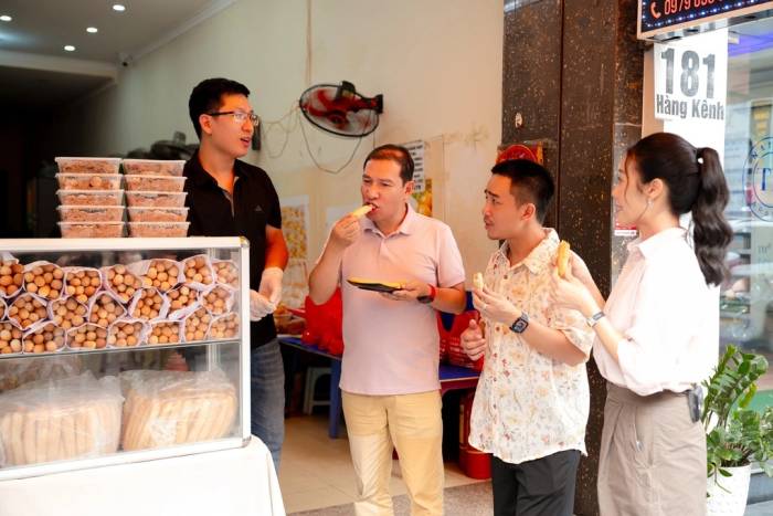 Nghệ sĩ Quang Thắng, Đỗ Duy Nam, Phí Linh (từ phải sang) thưởng thức món bánh mì que 3.000 một ổ. Ảnh: BTC