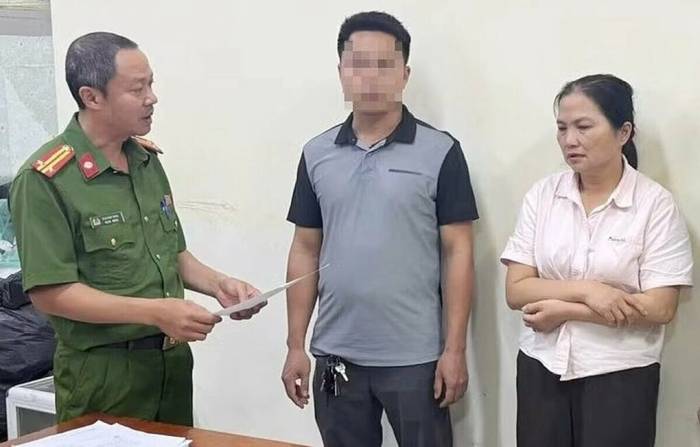 Công an tống đạt lệnh khởi tố bị can Tạ Thị Chi (áo hồng). Ảnh: Công an cung cấp