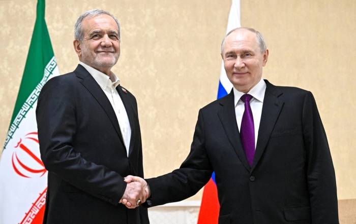 Tổng thống Nga Vladimir Putin (phải) và Tổng thống Iran Masoud Pezeshkian bắt tay nhau trong cuộc gặp tại Turkmenbashi ngày 8/10. Ảnh: AFP