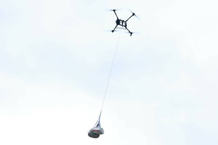 Những bao cà phê sau thu hoạch được vận chuyển từ vùng sản xuất xuống núi bằng UAV. Ảnh: Đàm Minh