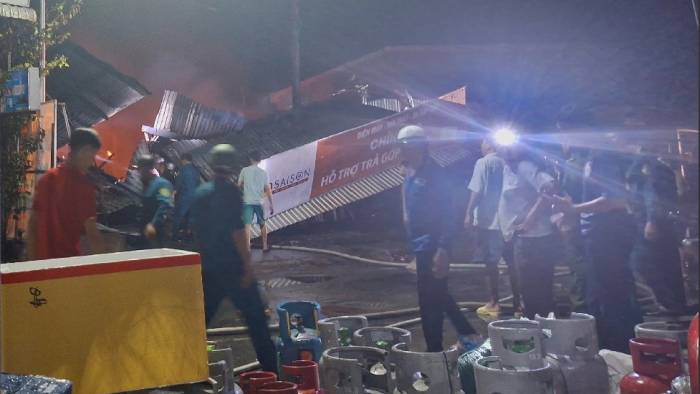 Hiện trường vụ cháy cửa hàng xe điện, người dân di dời gas từ nhà kho căn bên cạnh ra bên ngoài. Ảnh: Phương Vũ