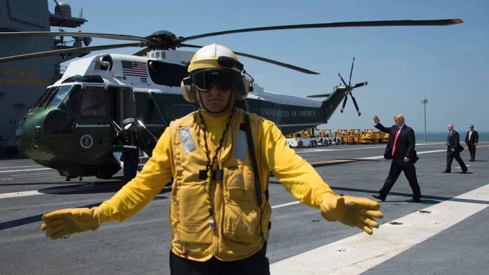 Tổng thống Donald Trump (phía sau) vẫy tay chào khi rời tàu sân bay USS Gerald R. Ford tại Norfolk, Virginia, hồi tháng 7/2017. Ảnh: AFP